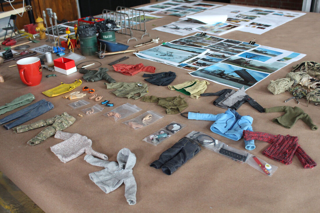 Miniature wardrobe and reference photography laid out for the production