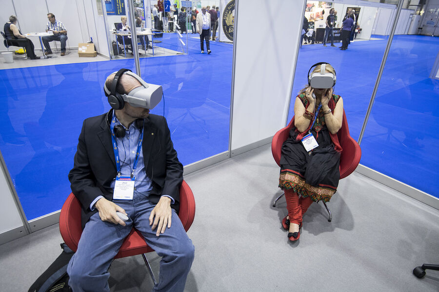 Two delegates seated inside the VR films at the convention