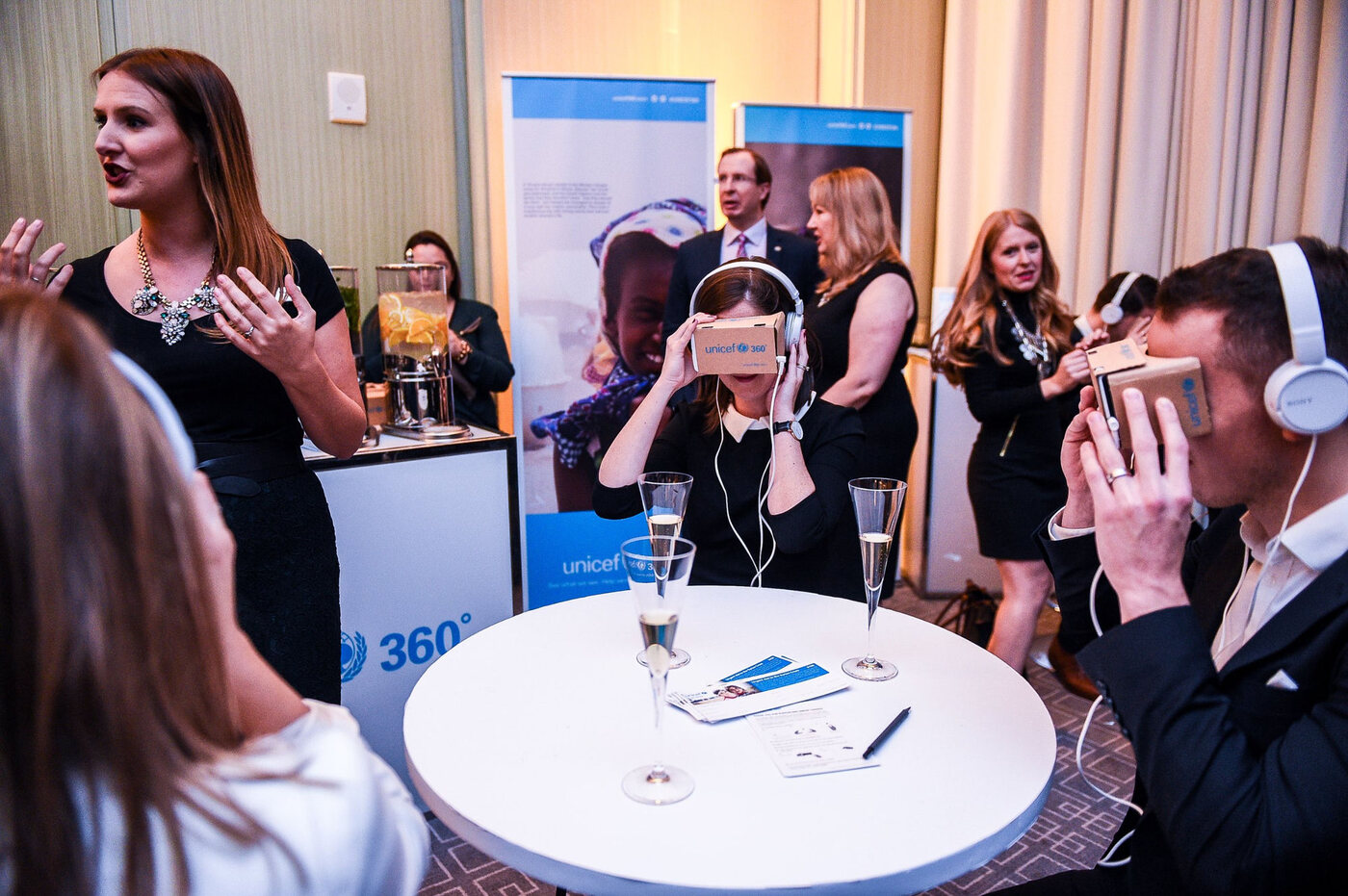 Guests trying UNICEF360 at a donor event as a host introduces the experience
